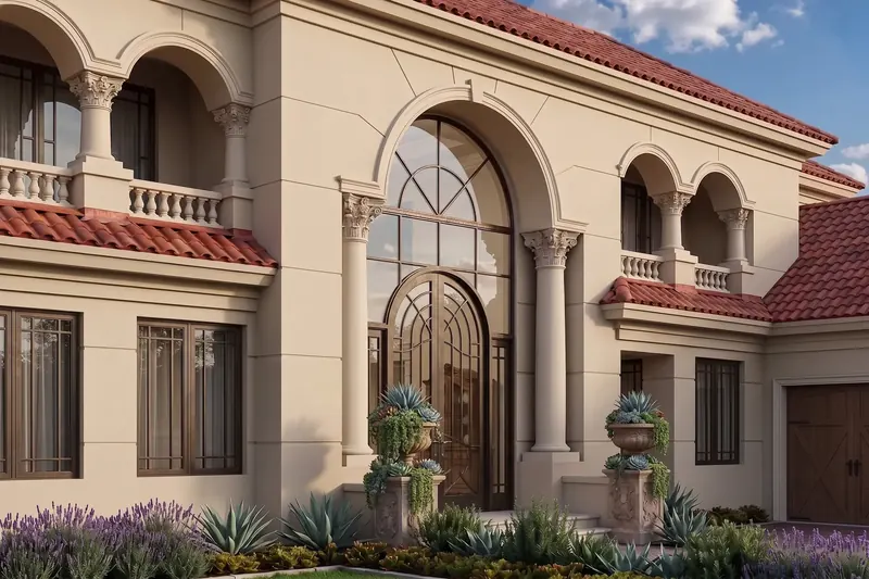 Italianate villa entry with an arched iron-and-glass door, Corinthian columns, balustraded balconies and red tile roofs