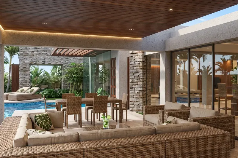 Covered lanai with wood ceiling, wicker seating and dining set, stacked stone walls and a pool among palms
