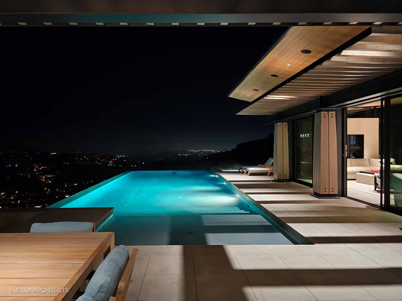 Infinity pool glowing at night above the city