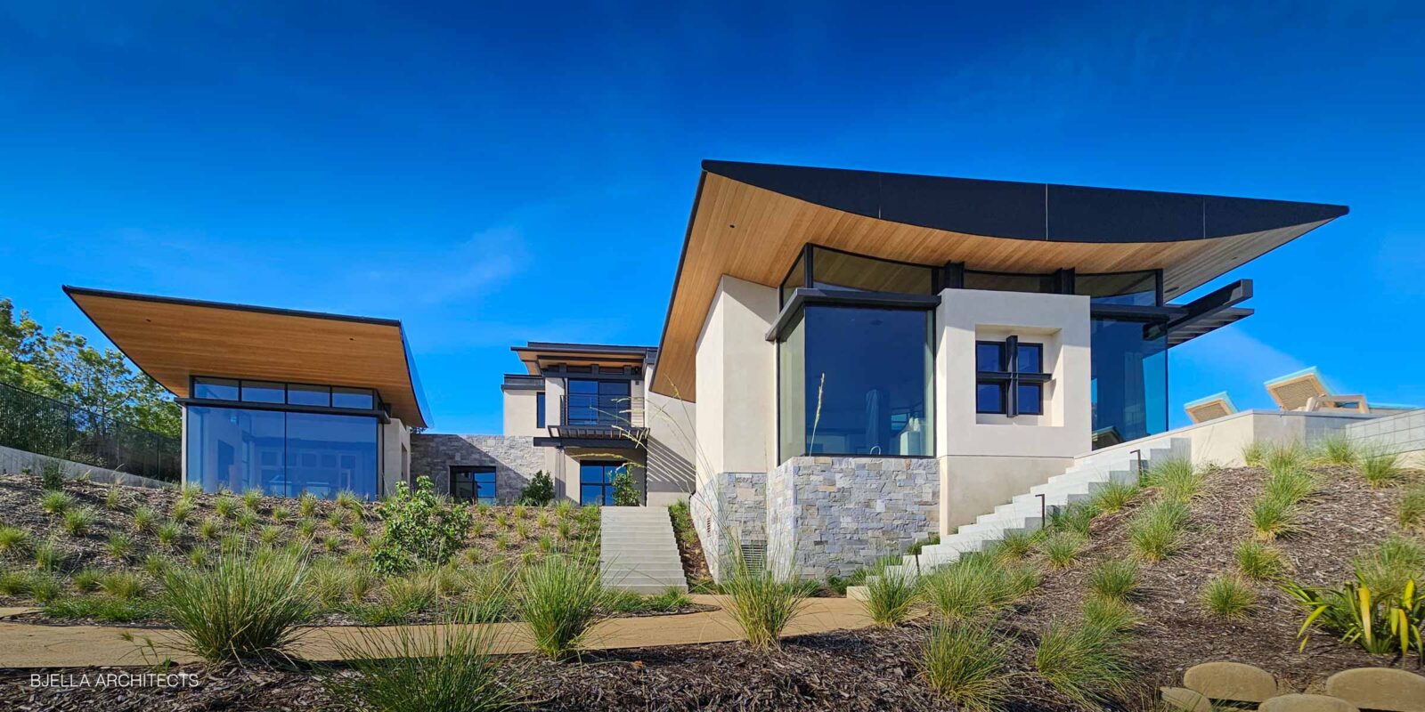 Modern California house exterior with a sweeping curved roofline