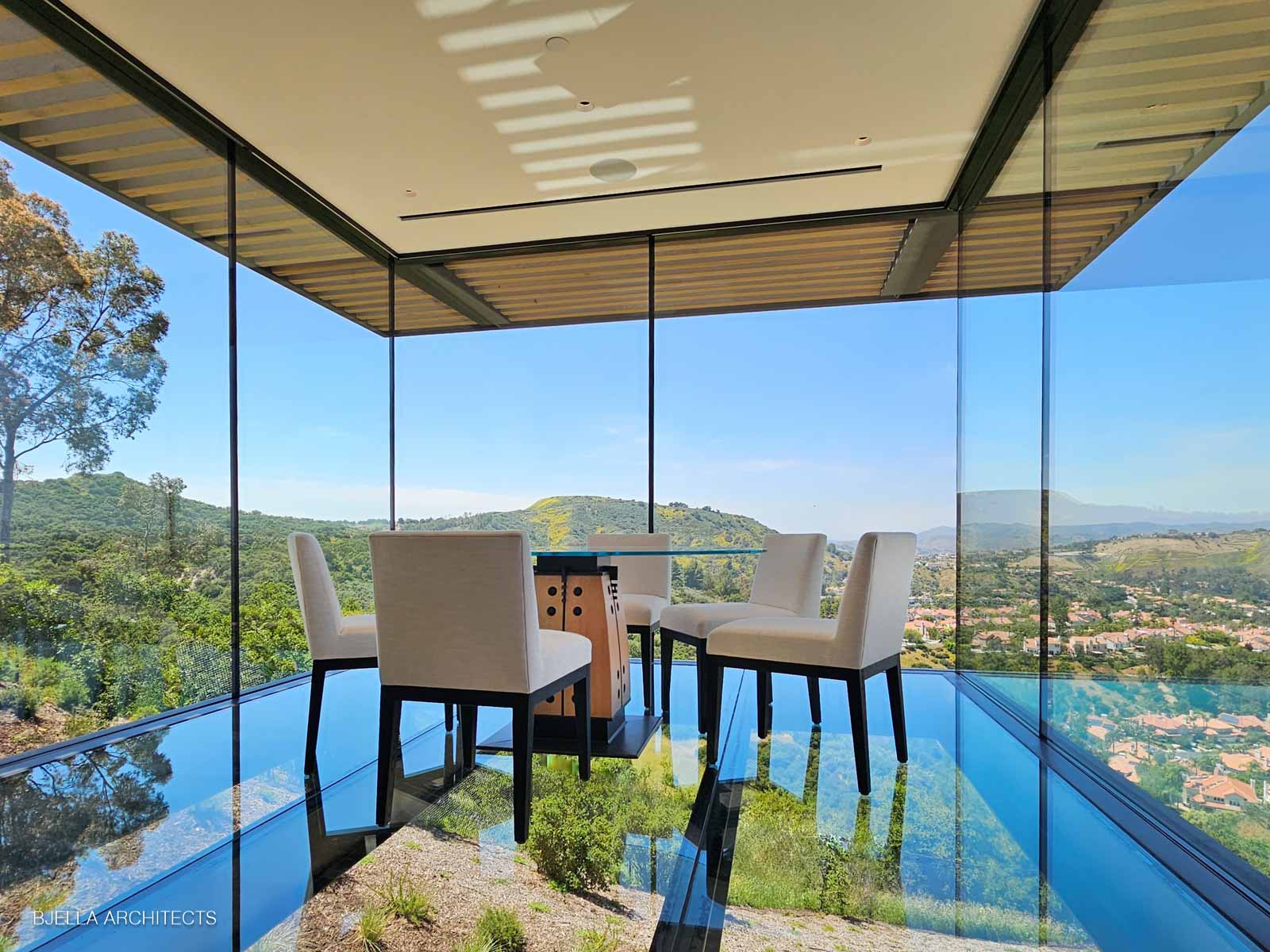 Glass-walled dining room floating above the hills