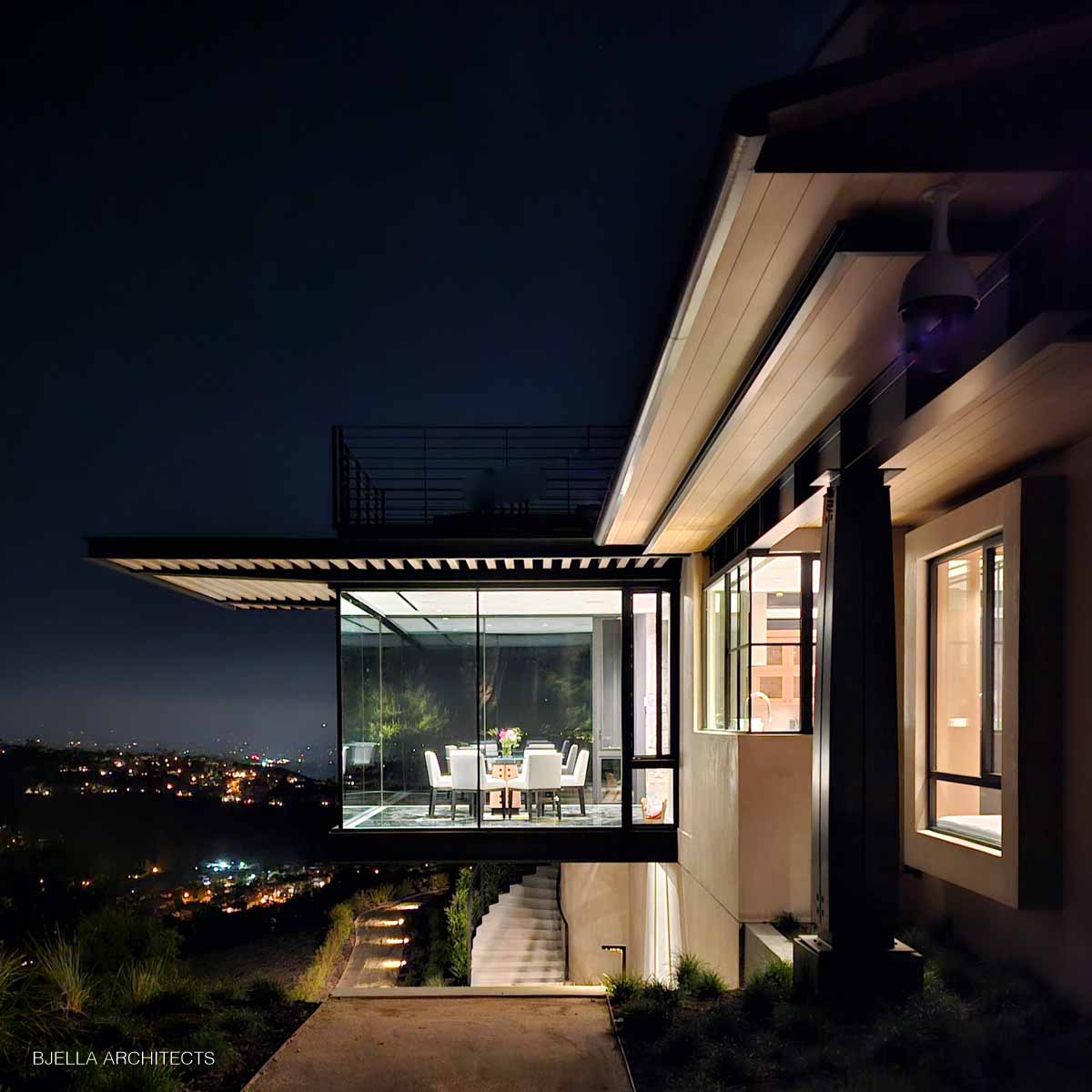Cantilevered glass room above city lights at night
