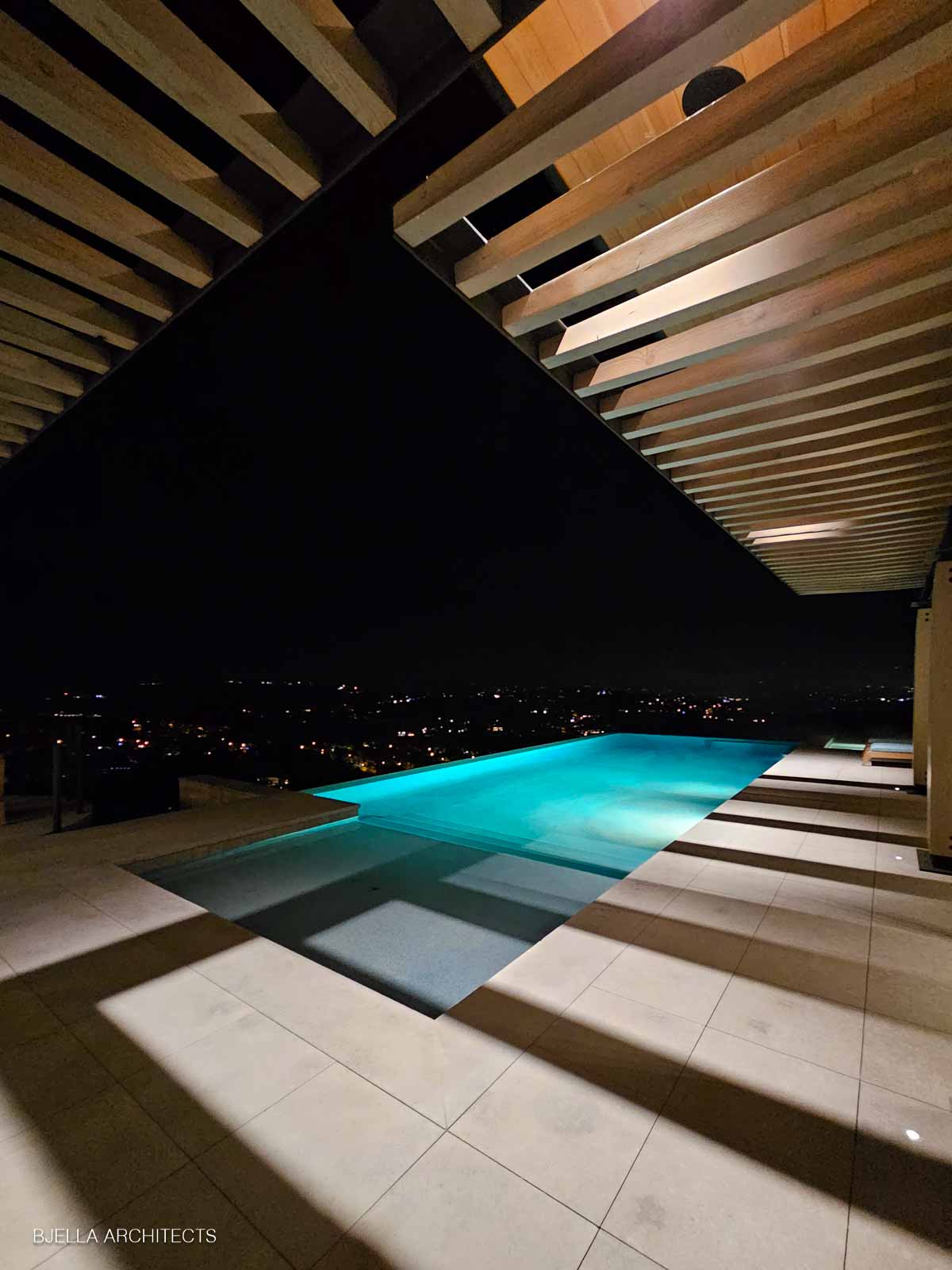 Pool terrace at night with city lights in the distance