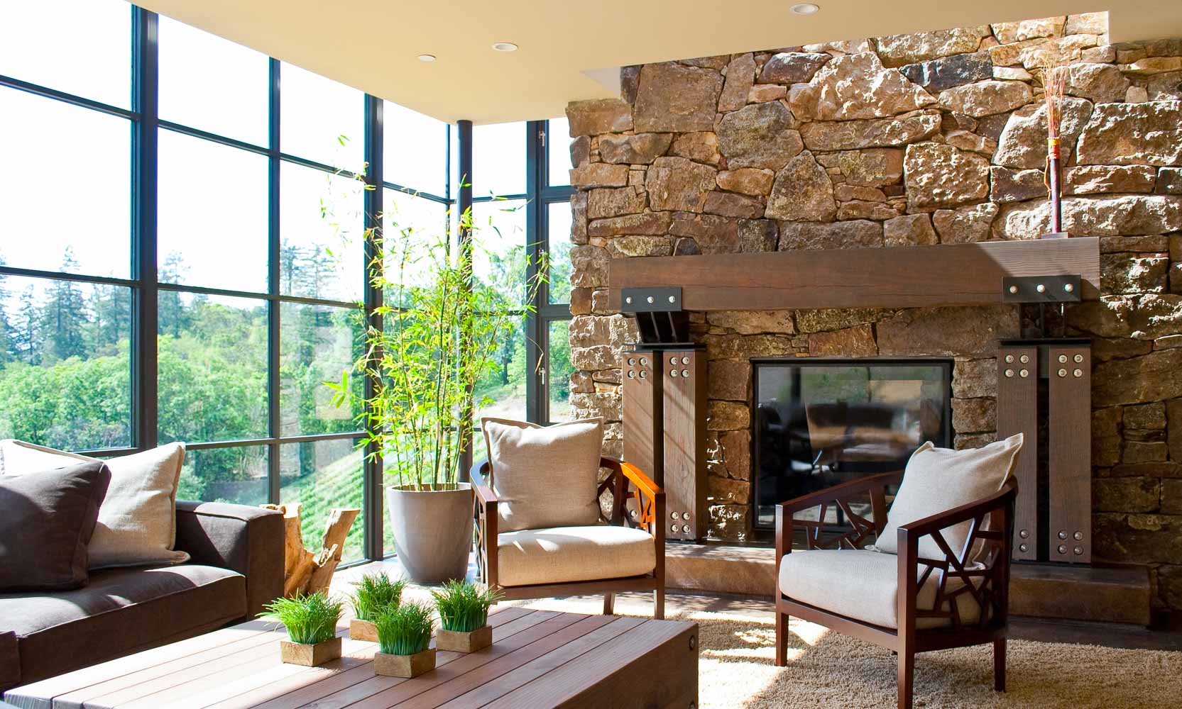 Living room with grand stone fireplace and walls of glass
