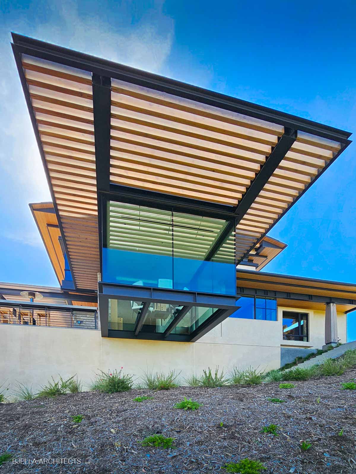 The winged canopy hovering over walls of glass