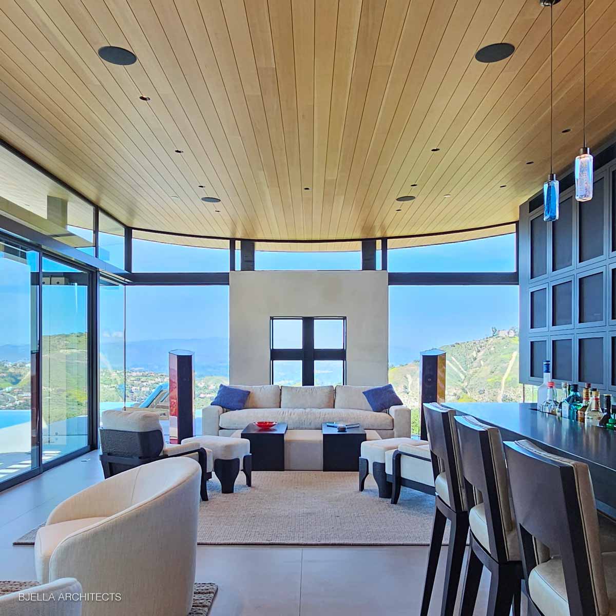 The curved glass living room facing the hills