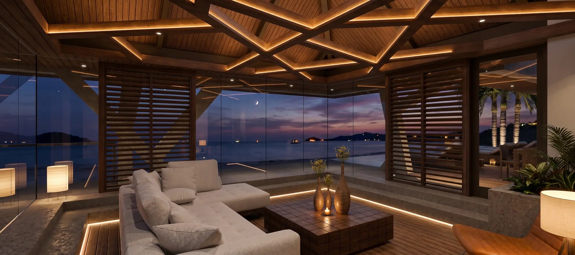 Canopy Pavilion living room at dusk, its illuminated beam ceiling glowing above a view of the sea and a crescent moon