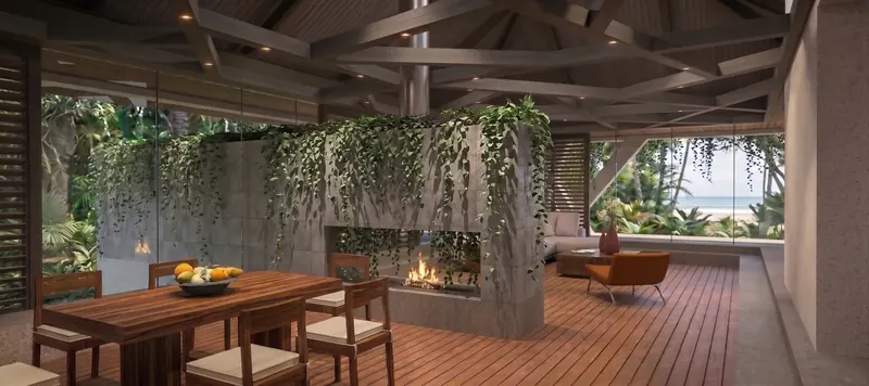 Wood dining table beside a vine-draped see-through fireplace wall under geometric timber beams