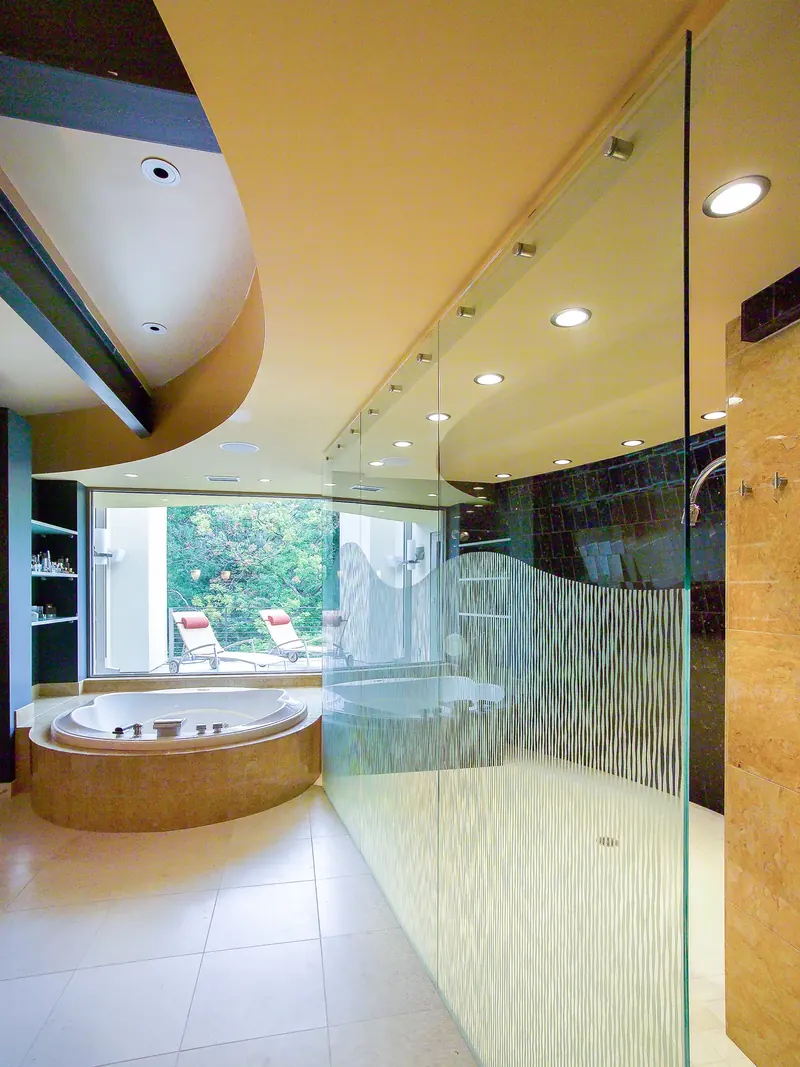 Bath with an etched-glass shower wall, curved ceiling and a tub before a window to a terrace