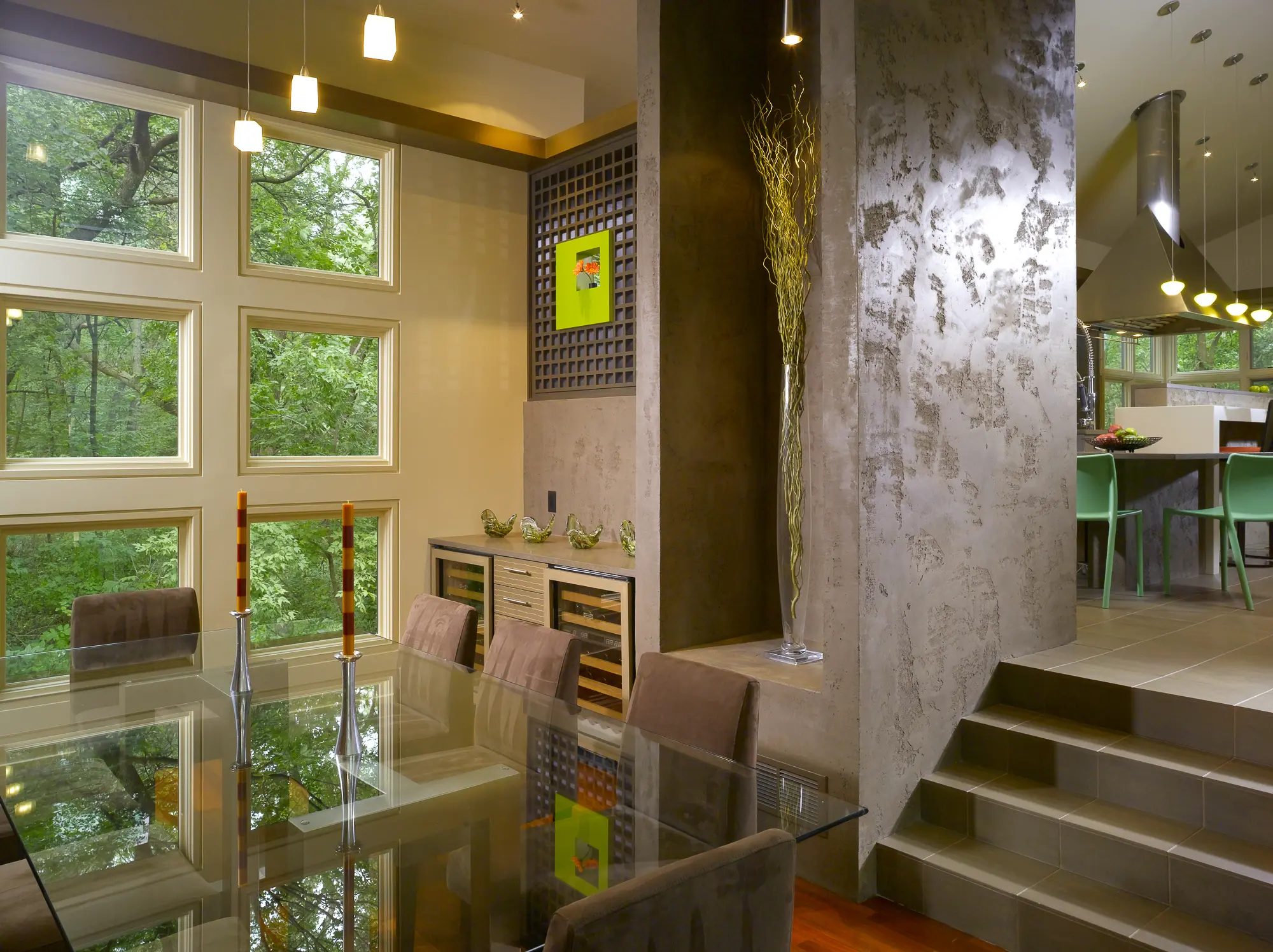 Dining area with a glass table, the grid wall art niche and a plaster column
