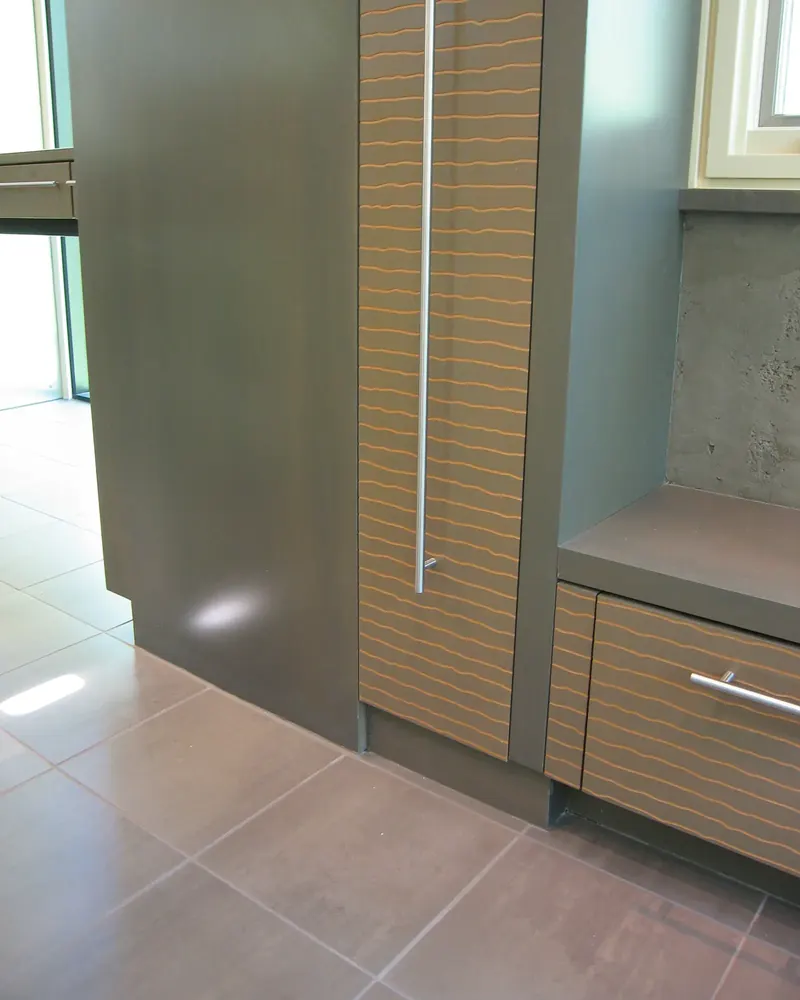 Grey cabinetry with horizontal wood inlays beside a window bench