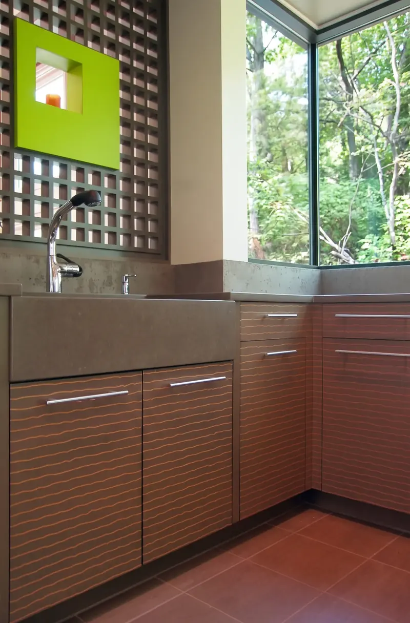 Sink corner with slatted cabinets beneath the green art niche