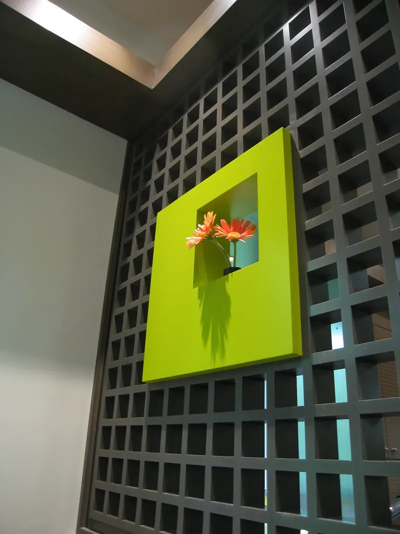 Bright green art niche set into the black grid divider wall