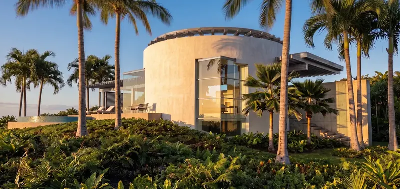 The Inland Oasis in Florida: a drum-shaped rotunda with a circular roof trellis among palms in warm late-day light