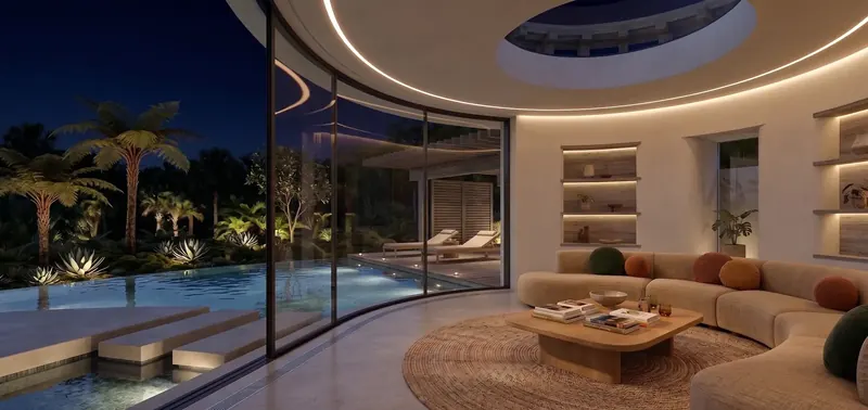 Guest house at night with cove lighting, lit shelving niches and the pool glowing past the curved glass