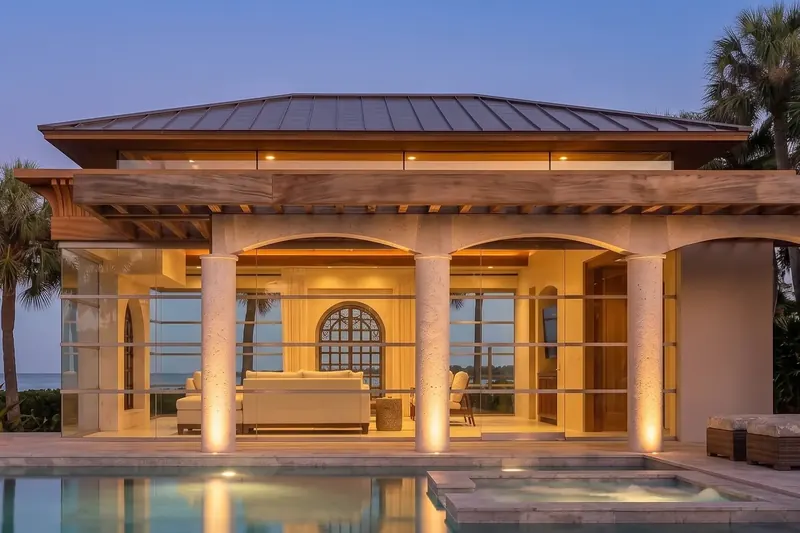 Front elevation of the colonnade, its arches and lit columns reflected in the pool and spa