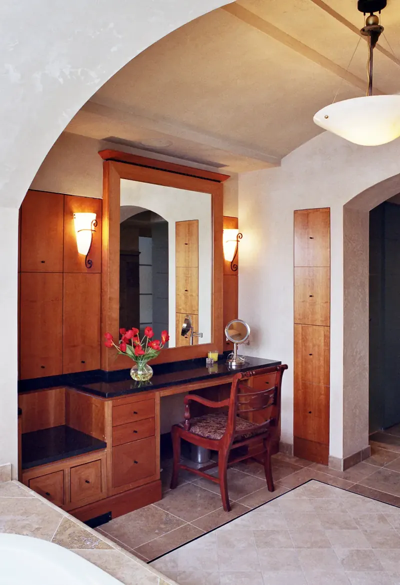 Wood makeup vanity set within an arched alcove of the en-suite