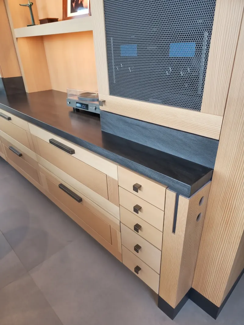 Wood credenza with a dark top, stacked drawers and a perforated metal panel above