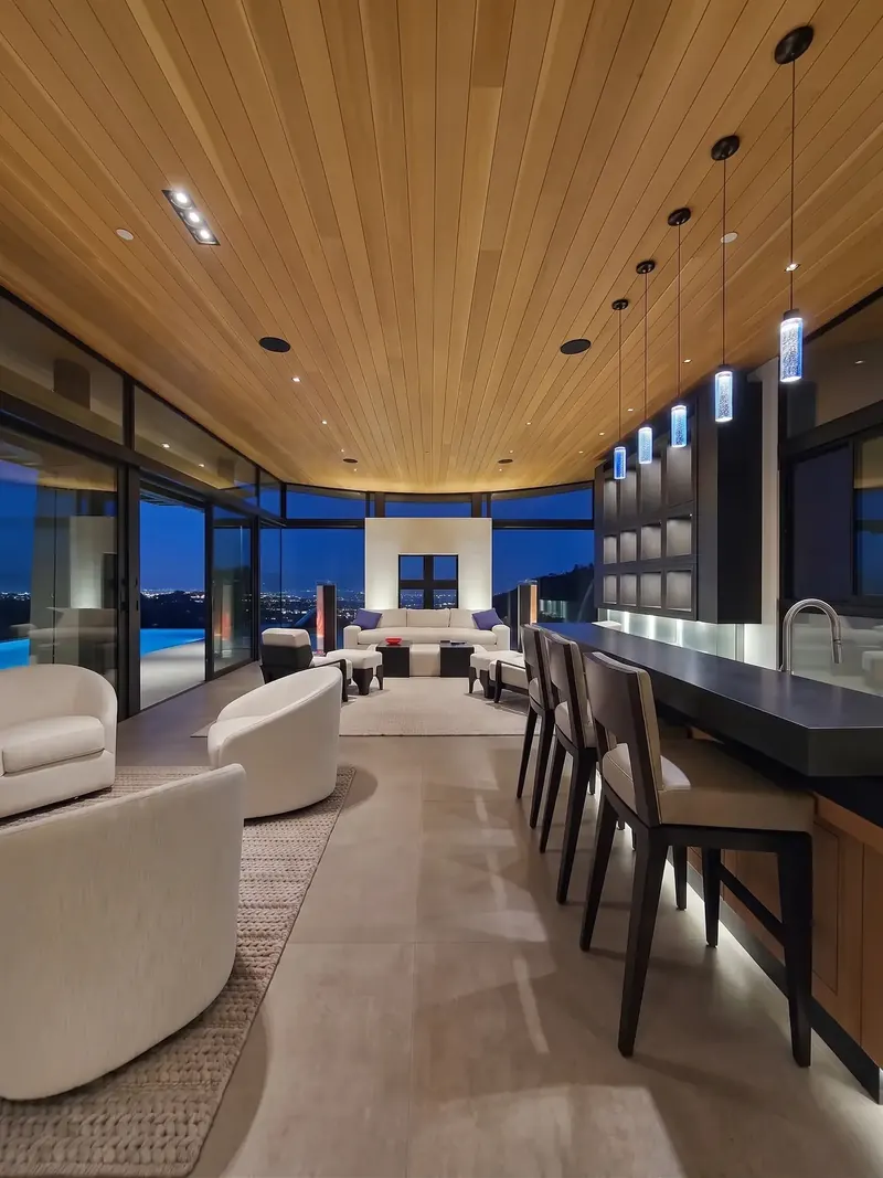 The View Room at dusk, a long wood ceiling leading past the bar to windows over the city lights
