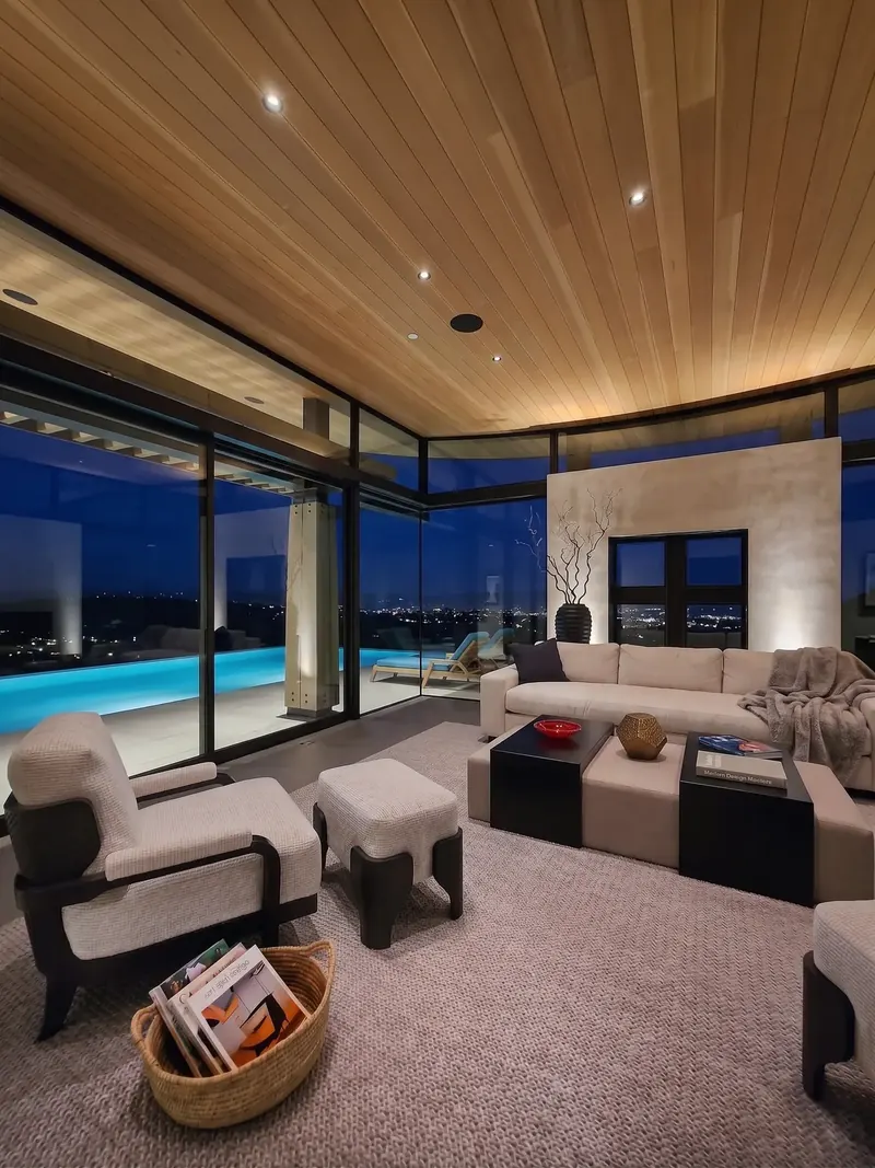 View Room seating at dusk, the glowing pool and city lights beyond floor-to-ceiling glass