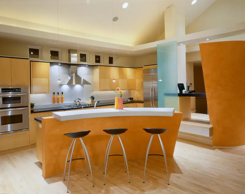Kitchen with a curved orange breakfast bar, maple cabinetry and stainless steel appliances
