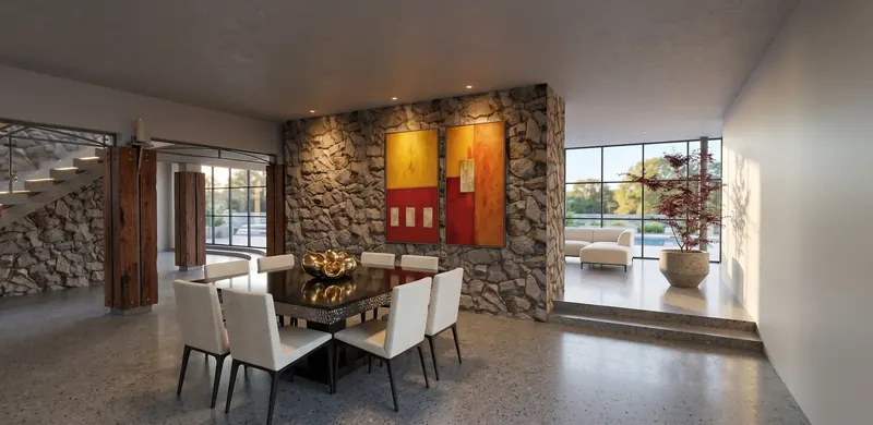 Dining table before a stone wall hung with red and gold paintings, with a raised sitting room and glass wall beyond
