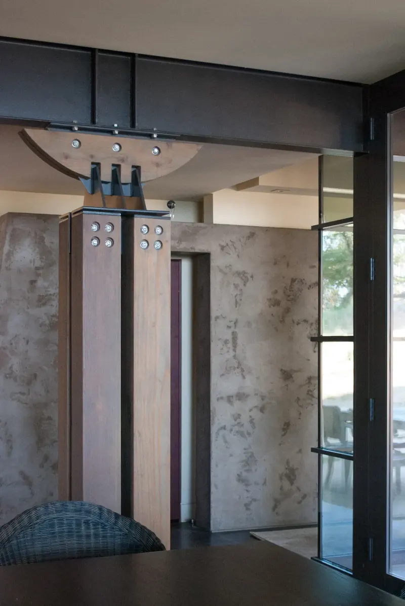 Custom timber-and-steel column against a plaster wall