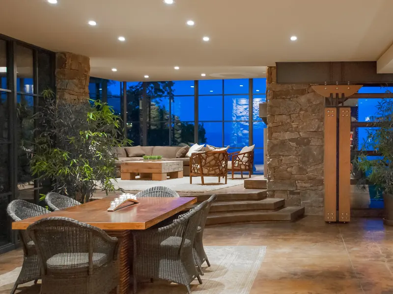 Open plan from the dining table to the living room, with stone columns and blue evening windows