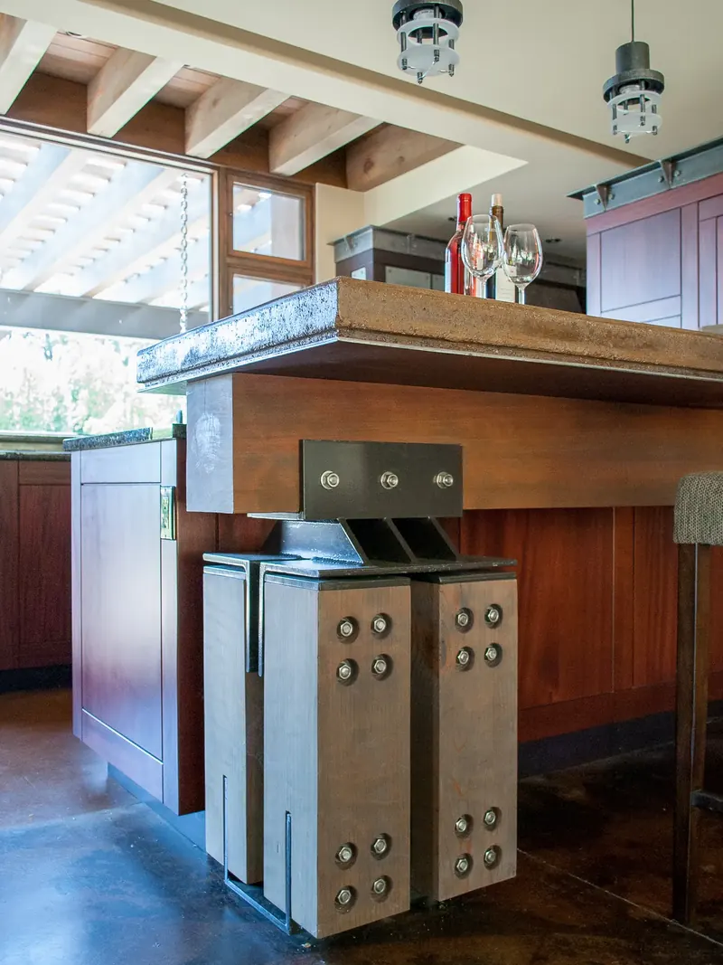 Bar counter carried on a timber support wrapped in bolted steel plates