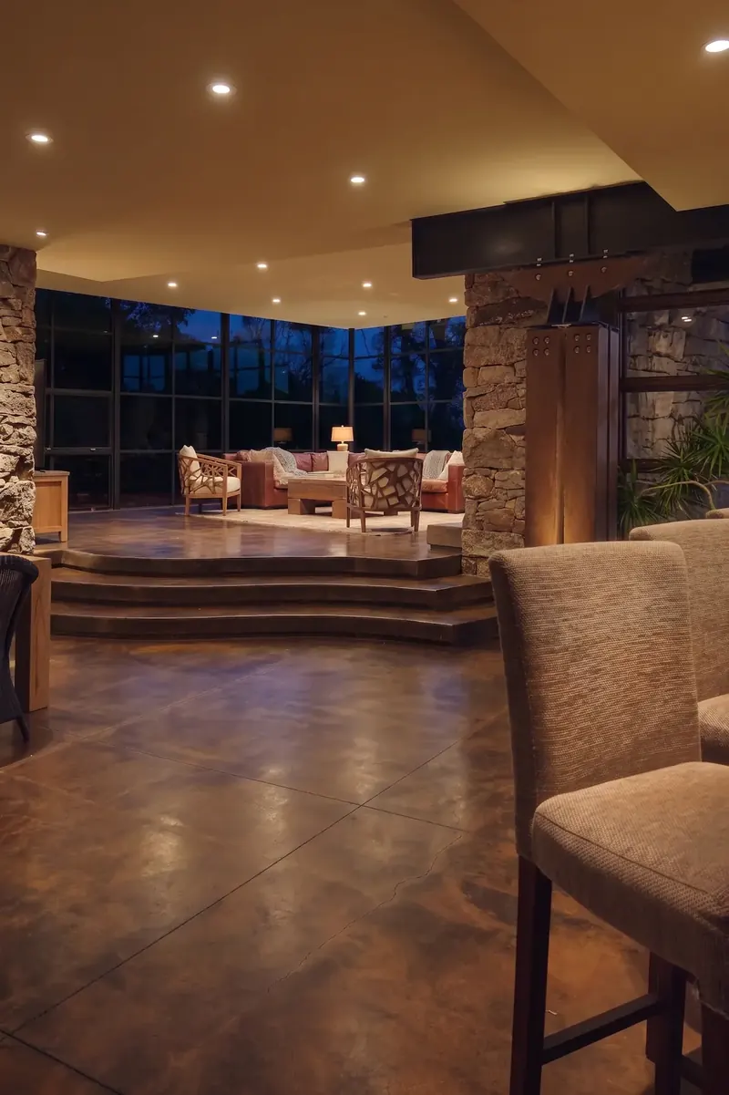 Night view from the kitchen to the glass living room and dark windows