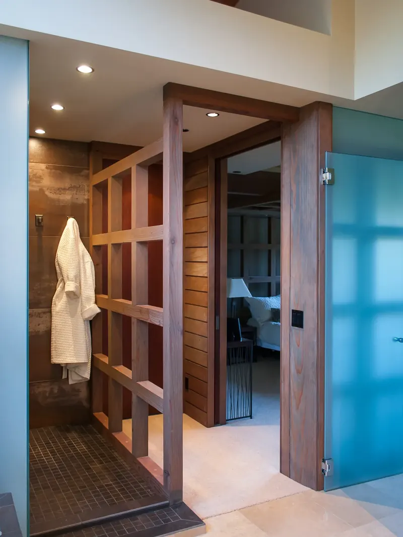 Shower entry framed in timber, with a blue frosted glass door and hanging robe