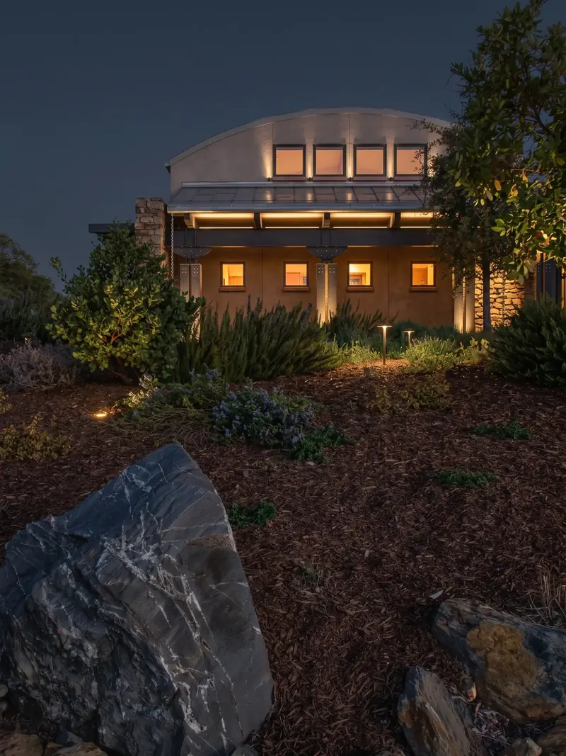 Winery facade lit at night with a boulder in the foreground