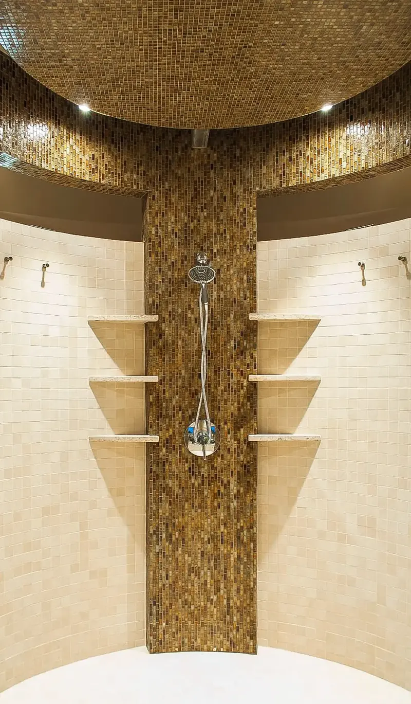 Round shower with cream tile, corner shelves and a bronze mosaic column rising into a mosaic ceiling, Seattle