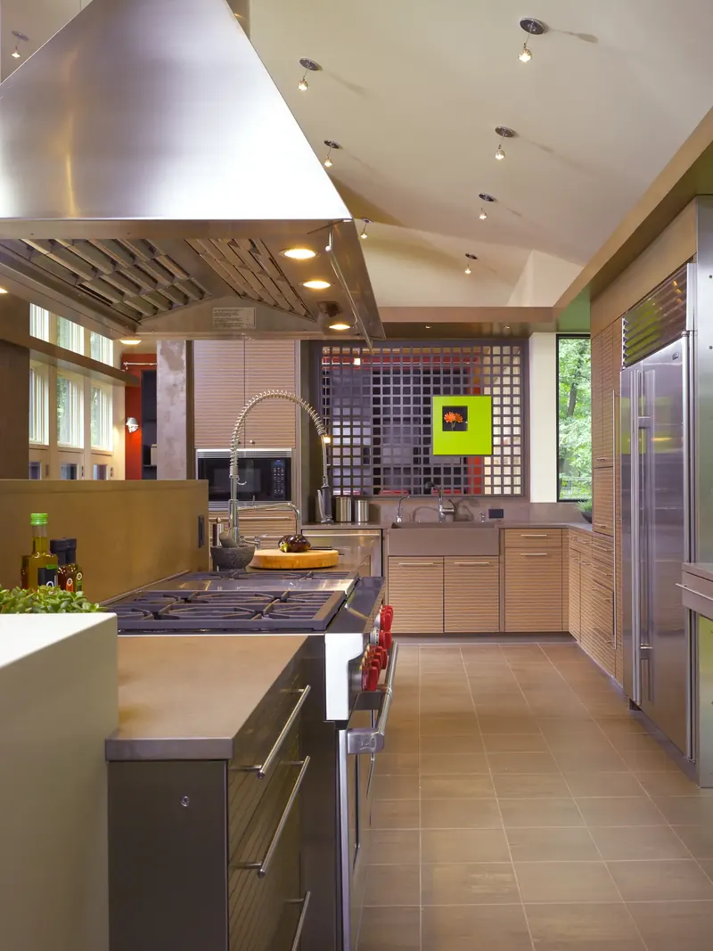 Kitchen with stainless range hood, tiled floor and the gridded screen at the far end