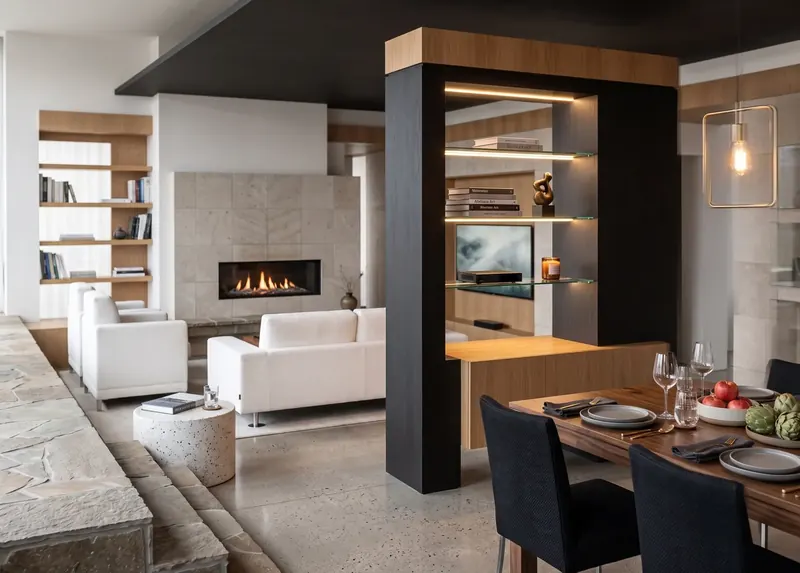Loft living area with white sofas, stone fireplace and a dark wood column with lit glass shelves