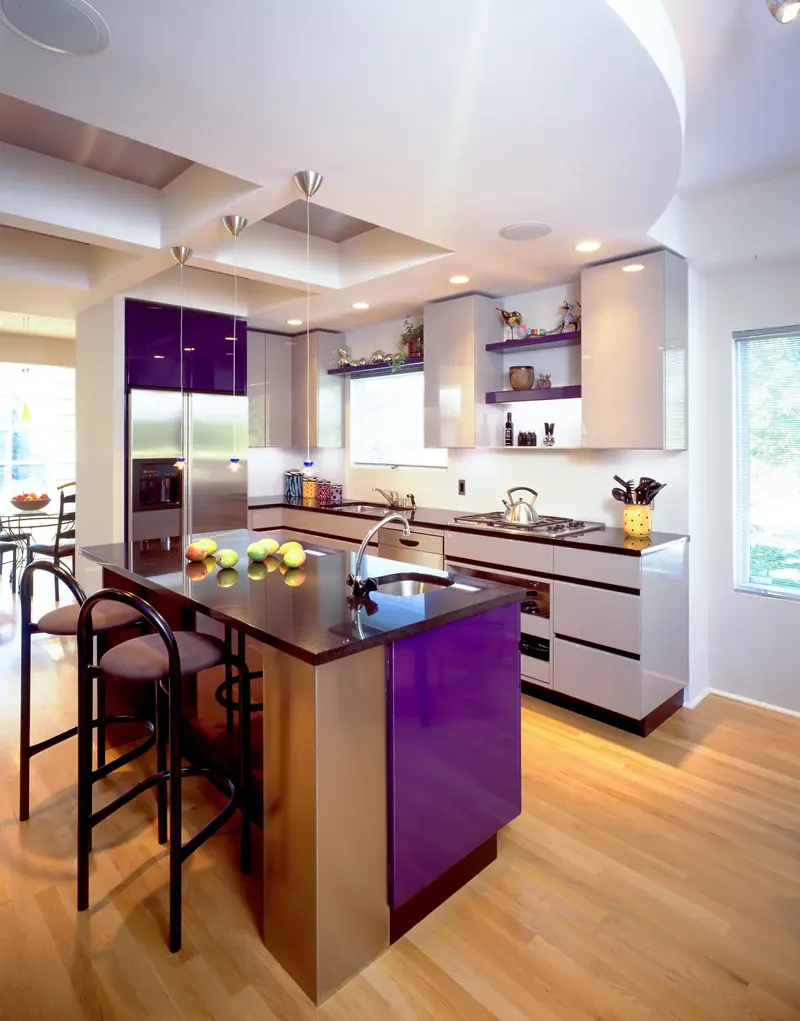 Bright kitchen with a purple and stainless island, gray gloss cabinets and wood floor, Florida