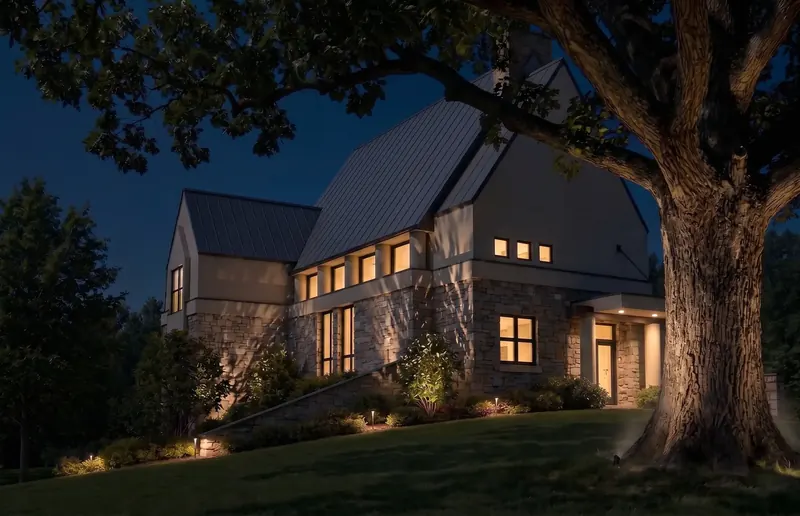 Post-modern house at night, clerestory windows glowing and the large oak uplit